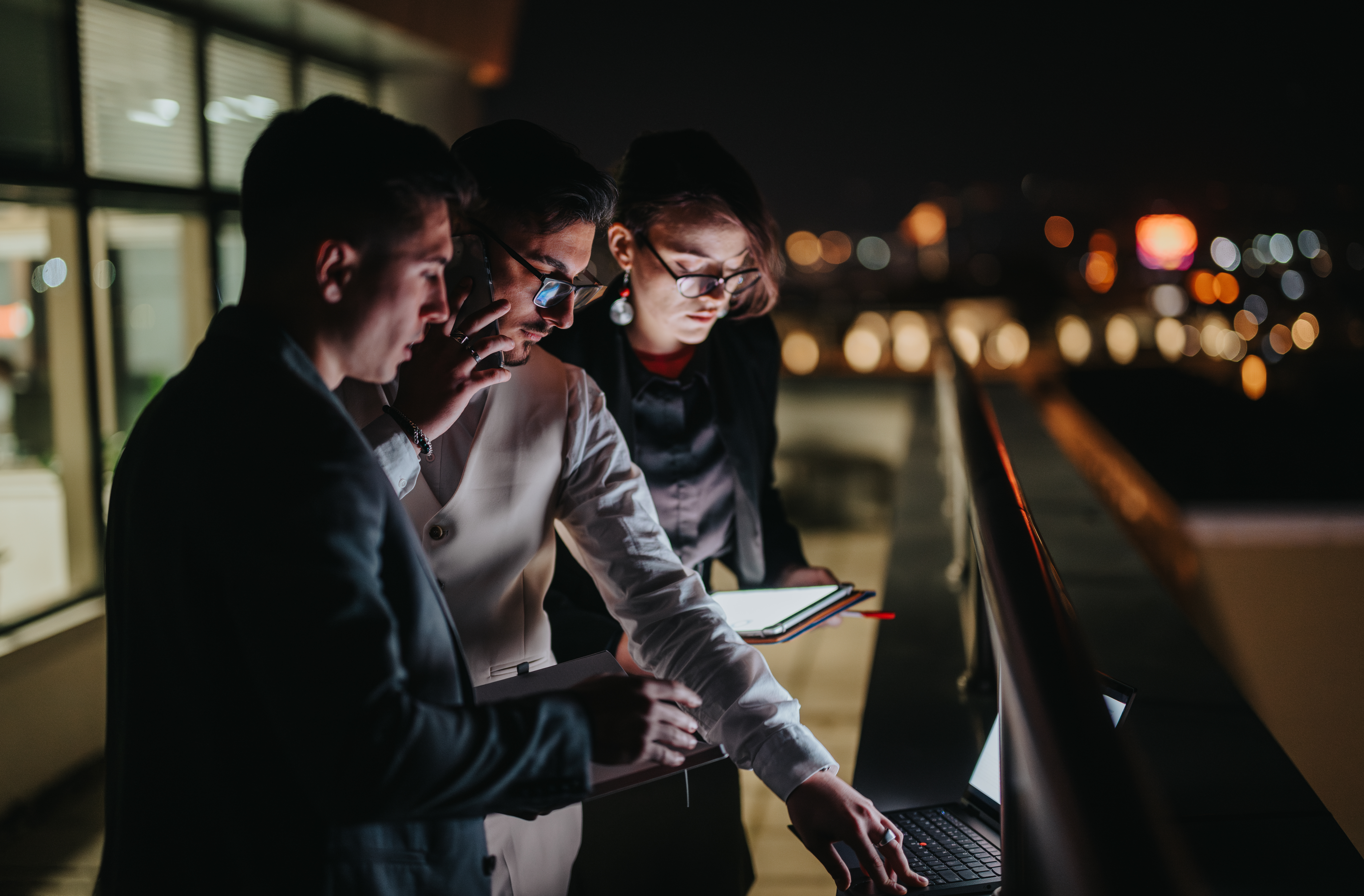 City officials collaborating at night using digital tools to analyze data and plan smart city operations.