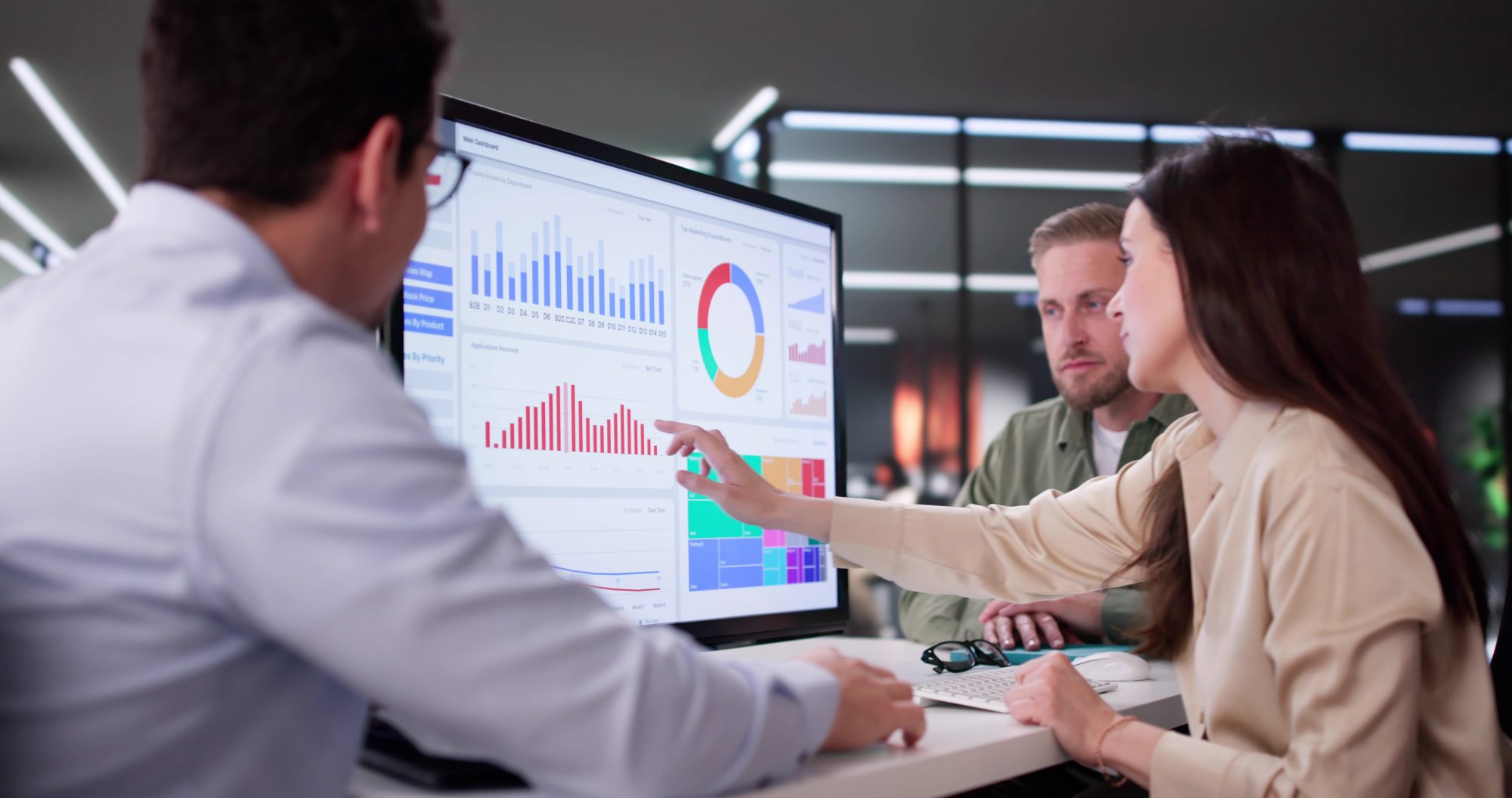 Business professionals collaborating around an analytics dashboard to share insights and make data-driven decisions securely.