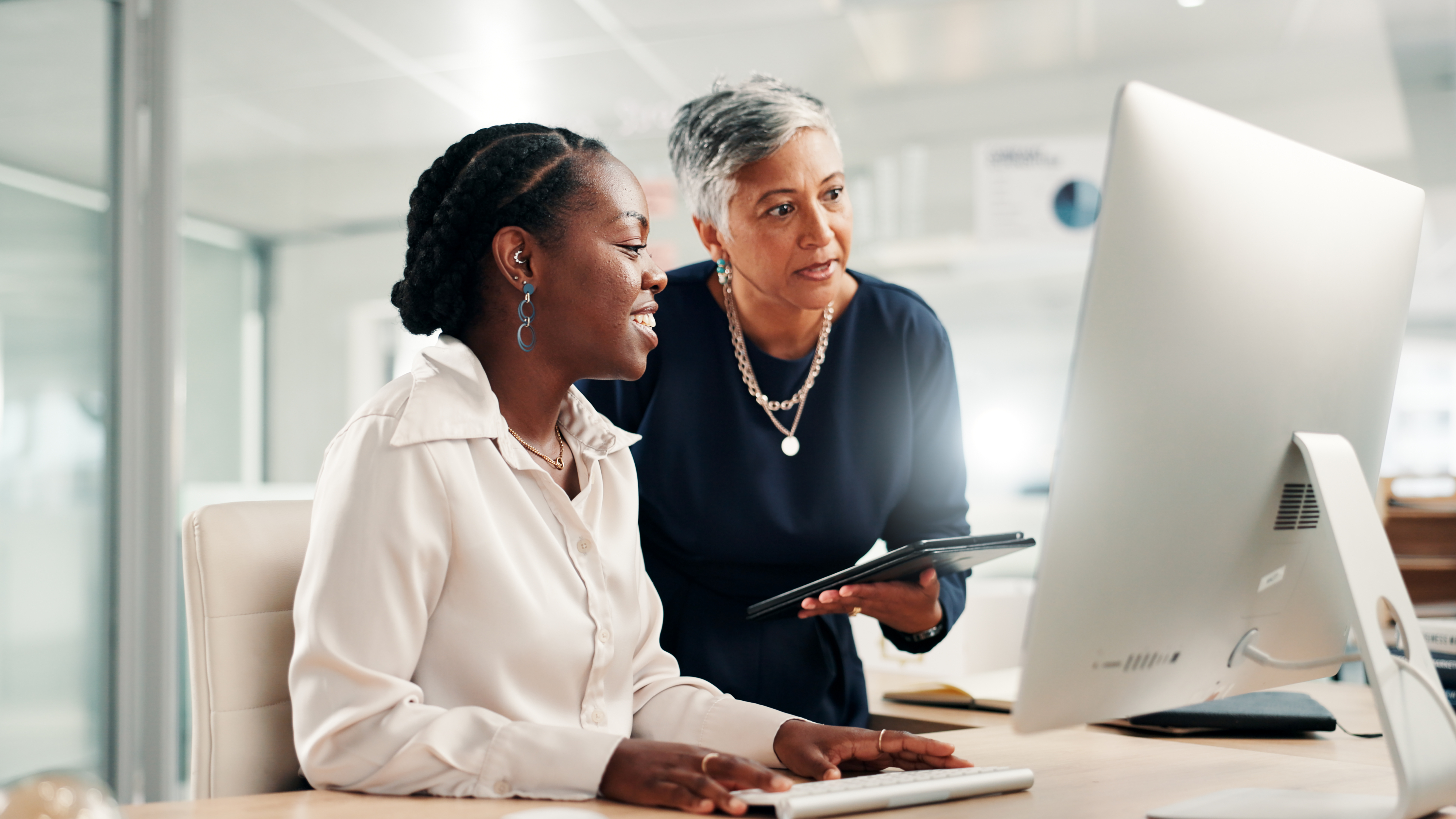 Diverse team collaborating with digital technology in a modern workplace, representing AI-enabled digital accessibility
