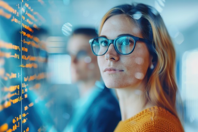 Two technology professionals analyzing data on a digital screen, representing agentic AI platform strategy in IT services.