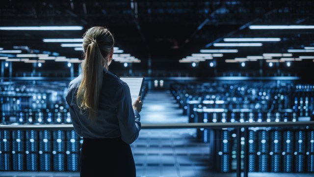 IT specialist surveys a large-scale data center, representing AI infrastructure investment at enterprise scale