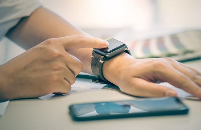Close-up of a person checking their smartwatch health data on their wrist