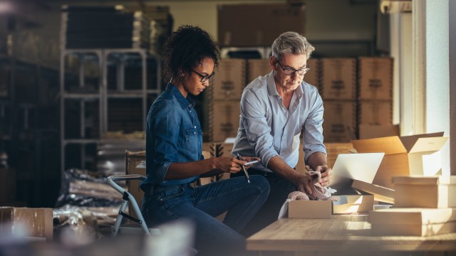 Small business owners reviewing inventory and shipment operations with a laptop, representing foundational retail strategy in the age of AI