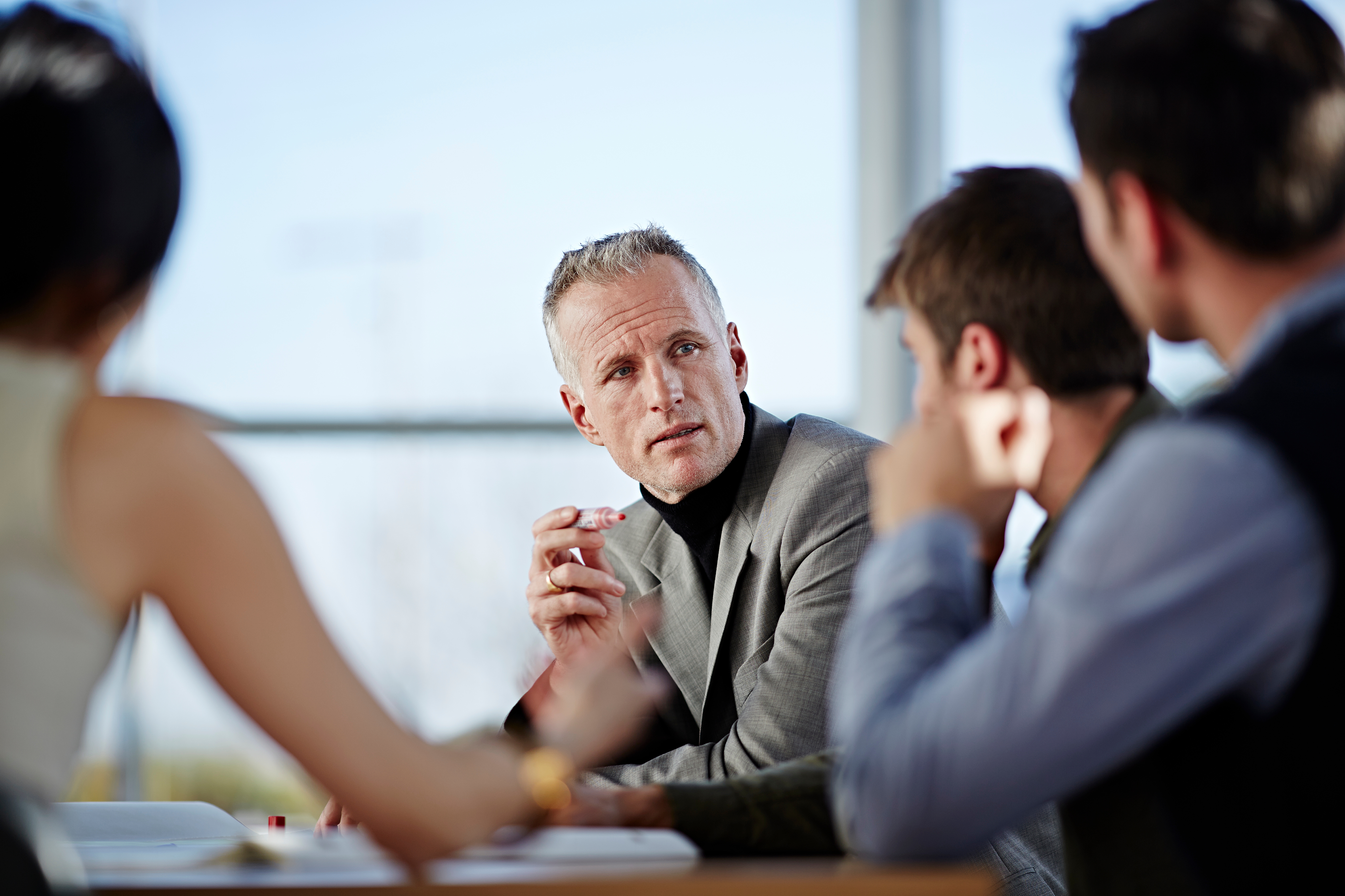 A cybersecurity leader explains framework requirements to stakeholders during a strategy meeting
