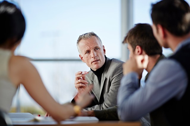 A cybersecurity leader explains framework requirements to stakeholders during a strategy meeting